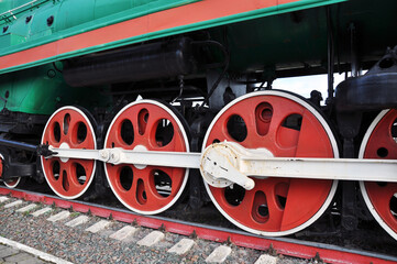 Naklejka premium Background, texture, Big wheels of a steam locomotive. Steam locomotive on rails. Red wheels.