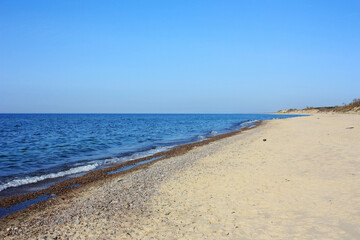 Fototapeta na wymiar Sandy shore of the blue Baltic Sea
