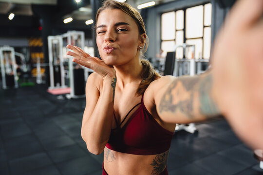 Beautiful sportswoman making selfie in gym