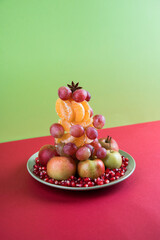 Alternative to The Christmas tree vegan tree made of fruit on a colored background .The concept of Christmas. Vertical orientation, copy space