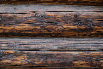 Wooden dark wall made of logs as background texture