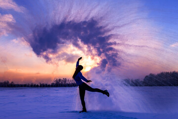 Silhouette of a sports girl at sunset in winter. Woman splashed boiling water on cold air.