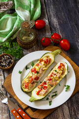 Healthy food. Baked zucchini stuffed with meat and tomatoes on rustic wooden table. Copy space.
