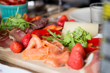 Plate with strawberries, ruccola and ham