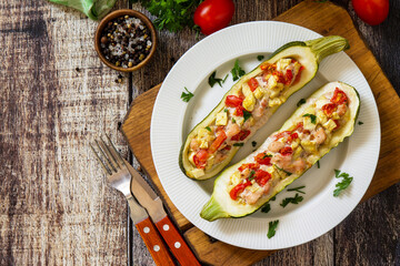 Healthy food. Baked zucchini stuffed with meat and tomatoes on rustic wooden table. Top view flat lay. Free space for your text.