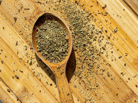 Close Up Basil Powder In Wooden Spoon On Chopping Board