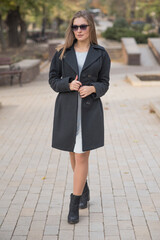 Obraz premium Beautiful and cute blonde girl with pleasure posing on the street