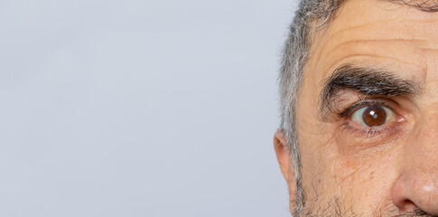 A man on a gray background banner with a place for text. Cataract - a disease of the human eye, clouding of the lens. Ophthalmology