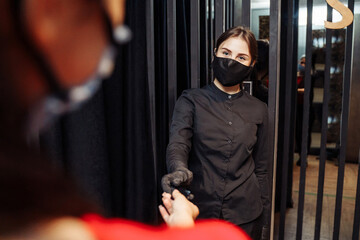 Fototapeta na wymiar New normal. New rules for visiting cafes and restaurants during the coronavirus pandemia covid-19. Maximum protection during communication with customers - a mask and gloves for employees