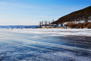 Fototapeta premium Beautiful landscape of frozen Lake Baikal. Listvyanka village in winter sunny frosty winter day.