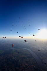 Skydiving people in freefall at beautiful sunset