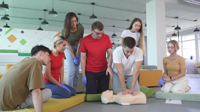 student in first aid class exercising reanimation on dummy, indoors
