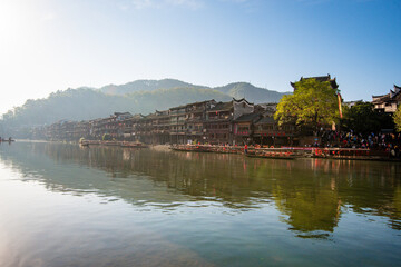 Fototapeta na wymiar the river, the boat, stone bridge and the old houses at ancient phoenix town in the morning at Hunan, China. 