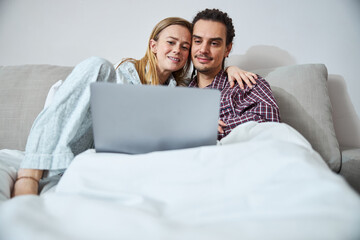 Beautiful young couple using laptop at home