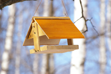 wooden bird feeder on blurred background close up