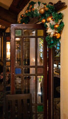 Vintage interior with opened old wooden door and traditional Christmas decorations. Shanghai, China, 12 05 2019