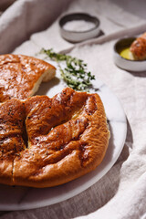 Homemade fresh baked Fougasse (French Bread) with thyme and olive oil on white background. Traditional Provencal dishes. Selective focus
