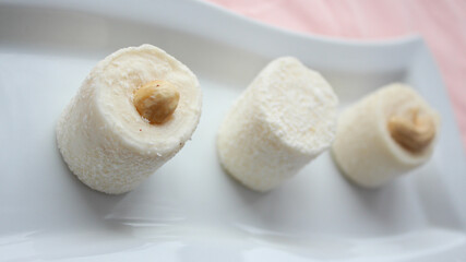 Marshmallow nougat sweets with nuts. Delicious dessert. Rolls of white nougat chocolates are served...