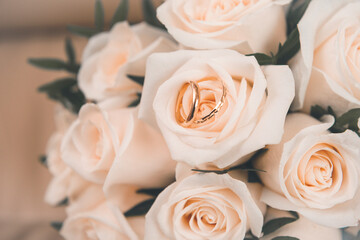 bouquet of white roses with 2 gold wedding rings