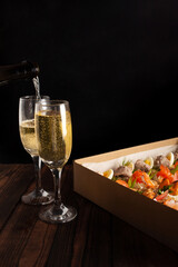 Champagne, tartlets, seafood salads. Cardboard box with food with home delivery. Gift for holiday, party, family dinner. Catering. Delicious snacks.