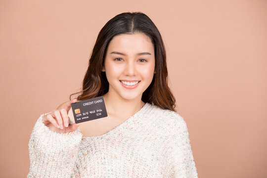 Young woman showing credit card image isolated on brown studio background