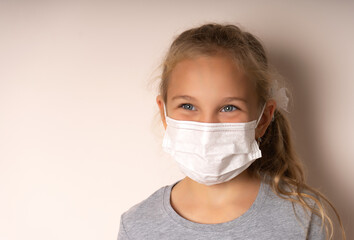 Little blonde girl wearing a medical mask