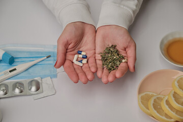 Medicine pills or herbs concept. Natural herbs. Two hands as a scale. Pandemic problem