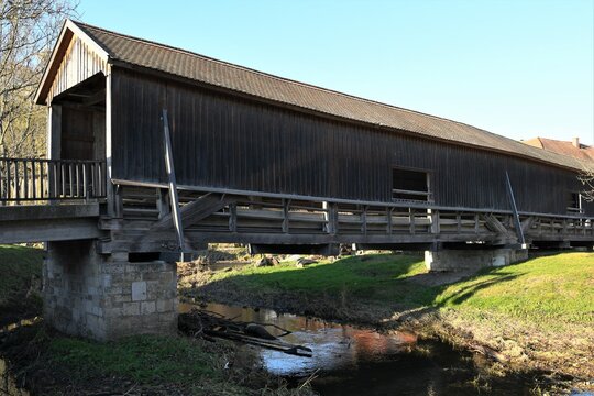 Die seit 1818 bestehende , &uuml;berdachte, historische Br&uuml;cke von Buchfartim im Kreis Apolda, Th&uuml;ringen- Die Br&uuml;cke ist eine einspurige 43 m lange Holzkonstruktion und &uuml;berquert das Fl&uuml;sschen Ilm.