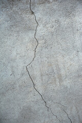 Plastered gray wall with a long split