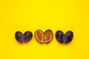 Fused fruits, double prunes. Ugly fruits in row on yellow background, place for text. Food waste reduction. Using in cooking imperfect products