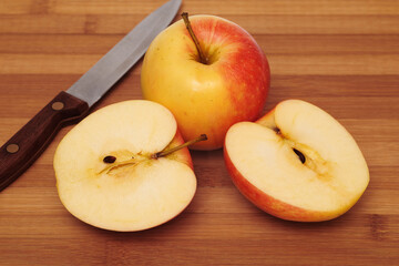 Whole apple and cut in half apple on cutting board