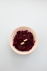 boiled beet with garlic in the bowl on blue background