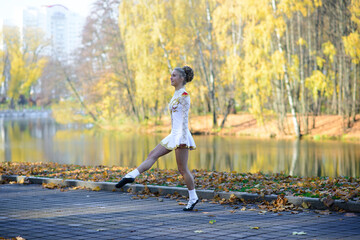 Ballerina dancing in nature among autumn leaves.