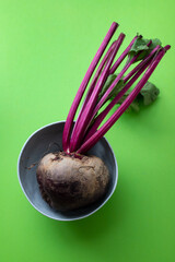 fresh beet root in a gray bowl on green background