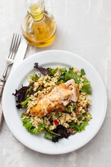 chicken with vegetables and quinoa on dish on ceramic background