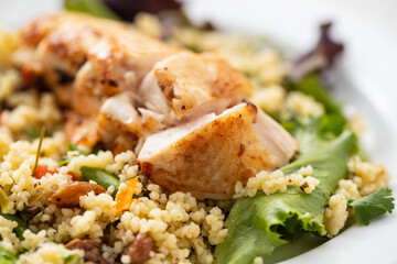 chicken with vegetables and quinoa on dish on ceramic background