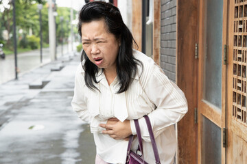 sick old senior woman suffering from stomachache, diarrhea, constipation, food poisoning, stomach...