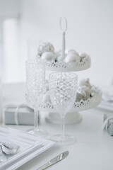 Glass and Plate with Cutlery, Balls Toys on Tray and Blank Christmas Present Packages on White Table. Empty Wineglasses, Dishware and Silverware on Restaurant on Domestic Celebration Desk