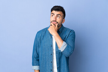Caucasian man over isolated blue background having doubts