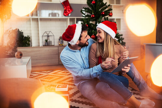 Sweet young couple using digital tablet at Christmas time