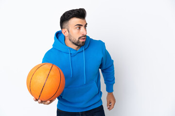 Caucasian man over isolated white background playing basketball