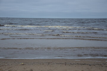 Grey sky over Baltic sea on a cold spring day with small waves and a clear horizon