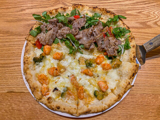 Delicious handmade cheese, shrimp and beef pizza in Italian restaurant