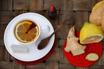 Top view with hot tea with lemon, ginger and propolis drops - obrazy, fototapety, plakaty