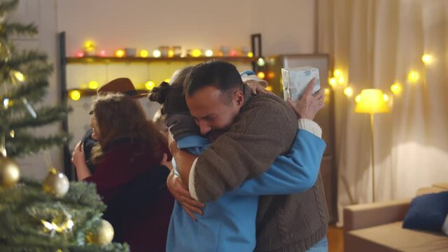 Grandparents visiting children and grandchildren and giving christmas present