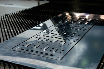 Metal sheet surface with holes of different sizes and forms after hydraulic punching and shearing...