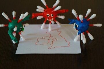 Figures of multi-colored viruses made of plasticine. Next to it is a drawn map of Britain.