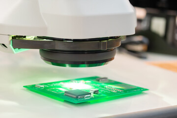 Printed circuit board under industrial microscope at plant, factory - close up. Quality control, examination, electronic, equipment, technology, manufacturing, production concept