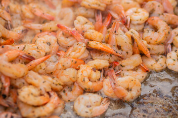 Process of grilling shrimps, prawns on brazier at summer local food market - close up view. Outdoor cooking, gastronomy, seafood, barbecue, street food concept