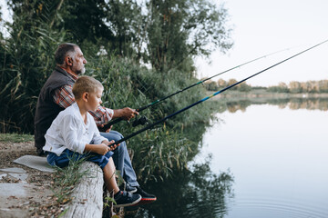 grandson and grandfather fishing together on the lake